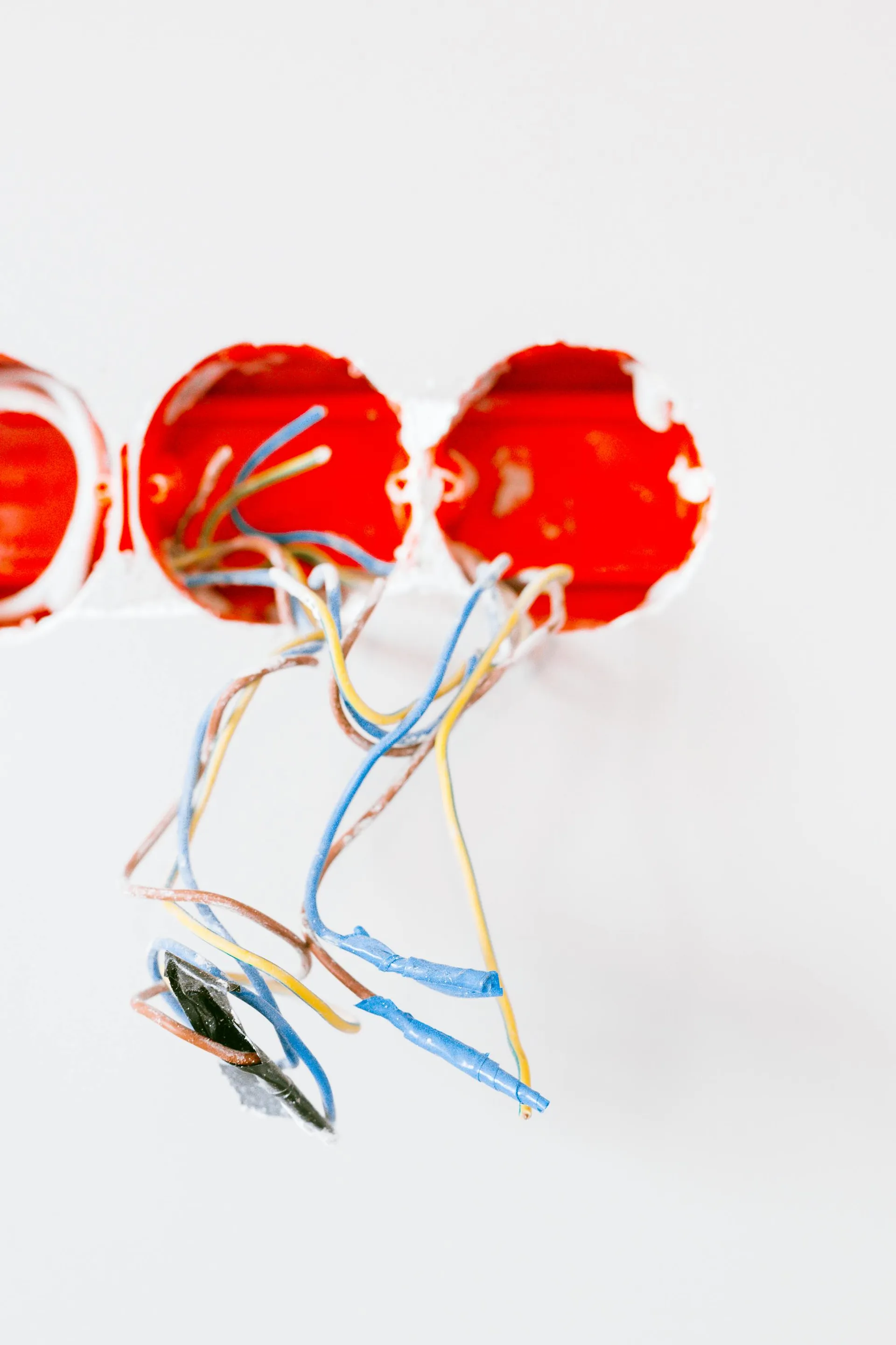 Exposed wires drawn out of red back-boxes during a refurbishment